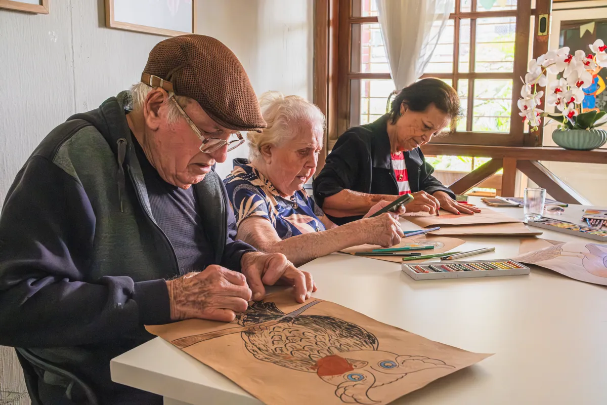 Arteterapia com moradores na mesa de atividades