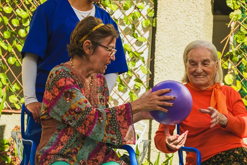 Moradoras brincando com bola, acompanhadas pela equipe, na unidade Calafate/Prado