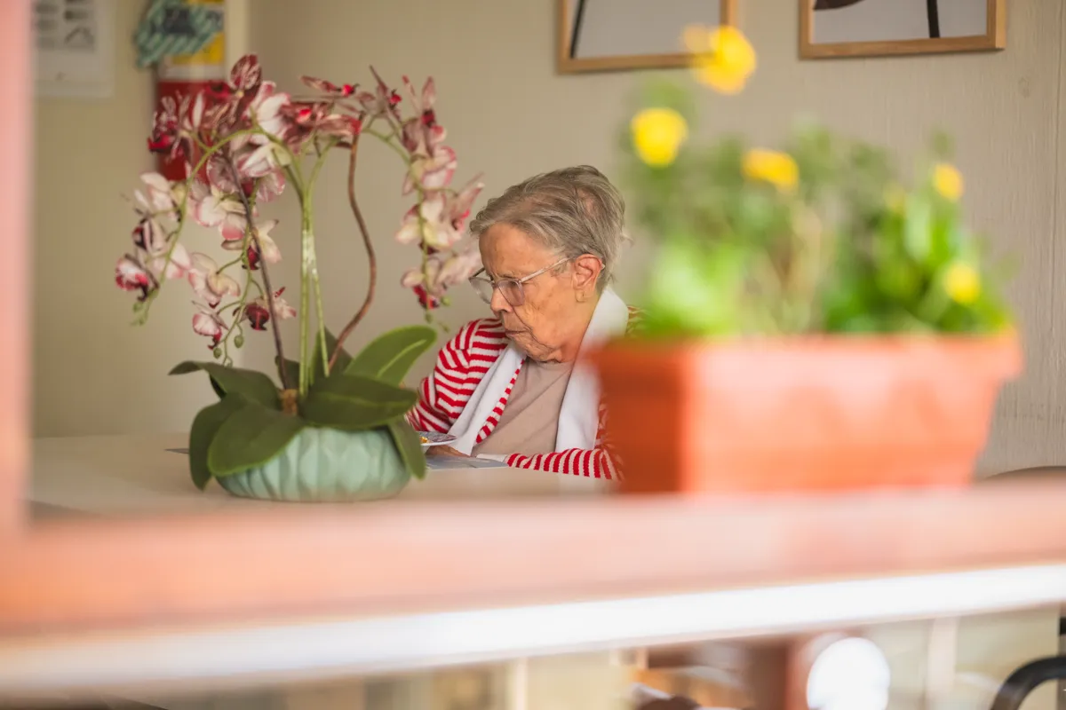 Moradora na varanda com orquídeas, na moradia permanente