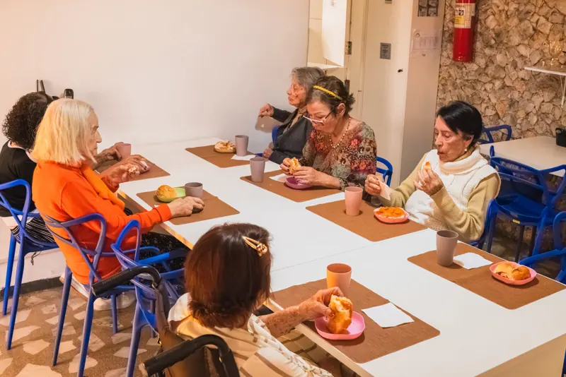 Moradoras reunidas à mesa do refeitório na unidade Calafate/Prado