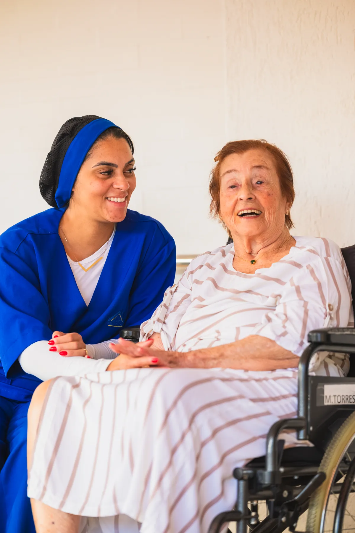 Cuidadora sorrindo com moradora