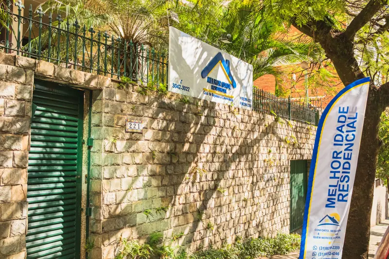 Fachada da unidade Gutierrez, com muro de pedra e portão verde
