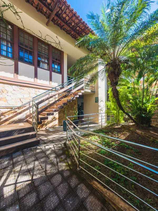 Jardim com palmeira e escada com corrimão na unidade Gutierrez