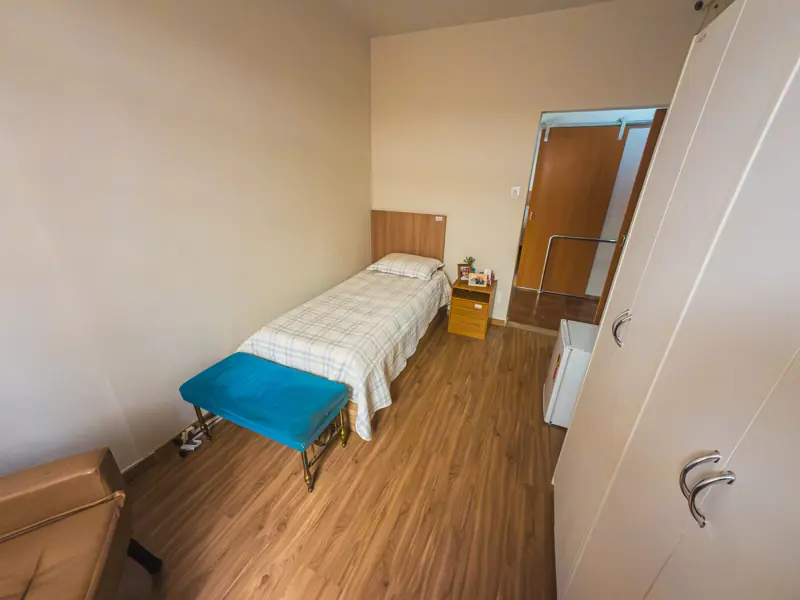 Quarto individual com piso de madeira na unidade Gutierrez